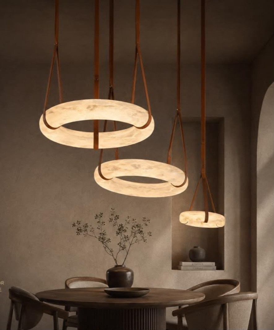 Three illuminated ring pendant lights above a dining table